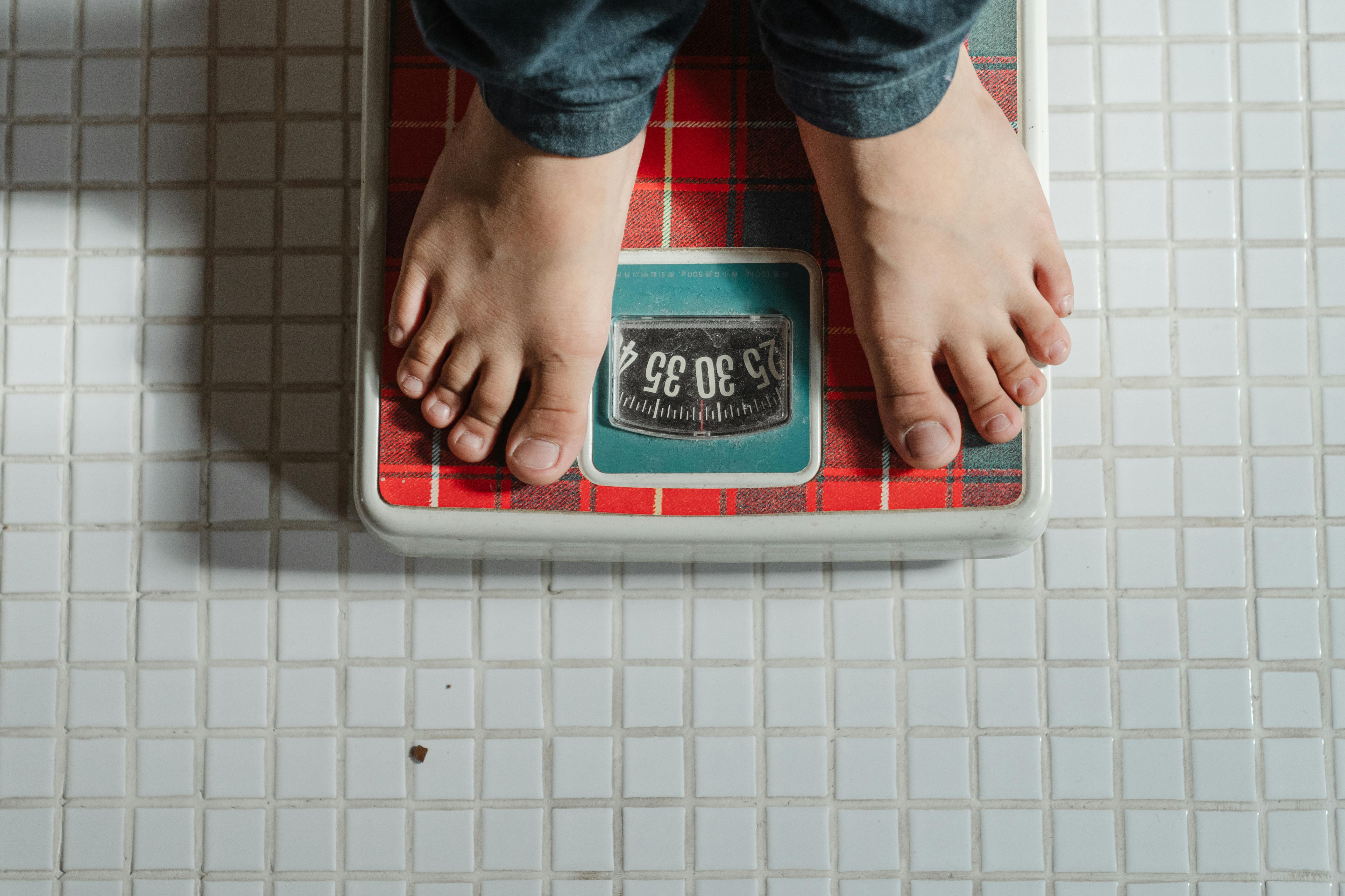 A man on weighing scale measuring his weight