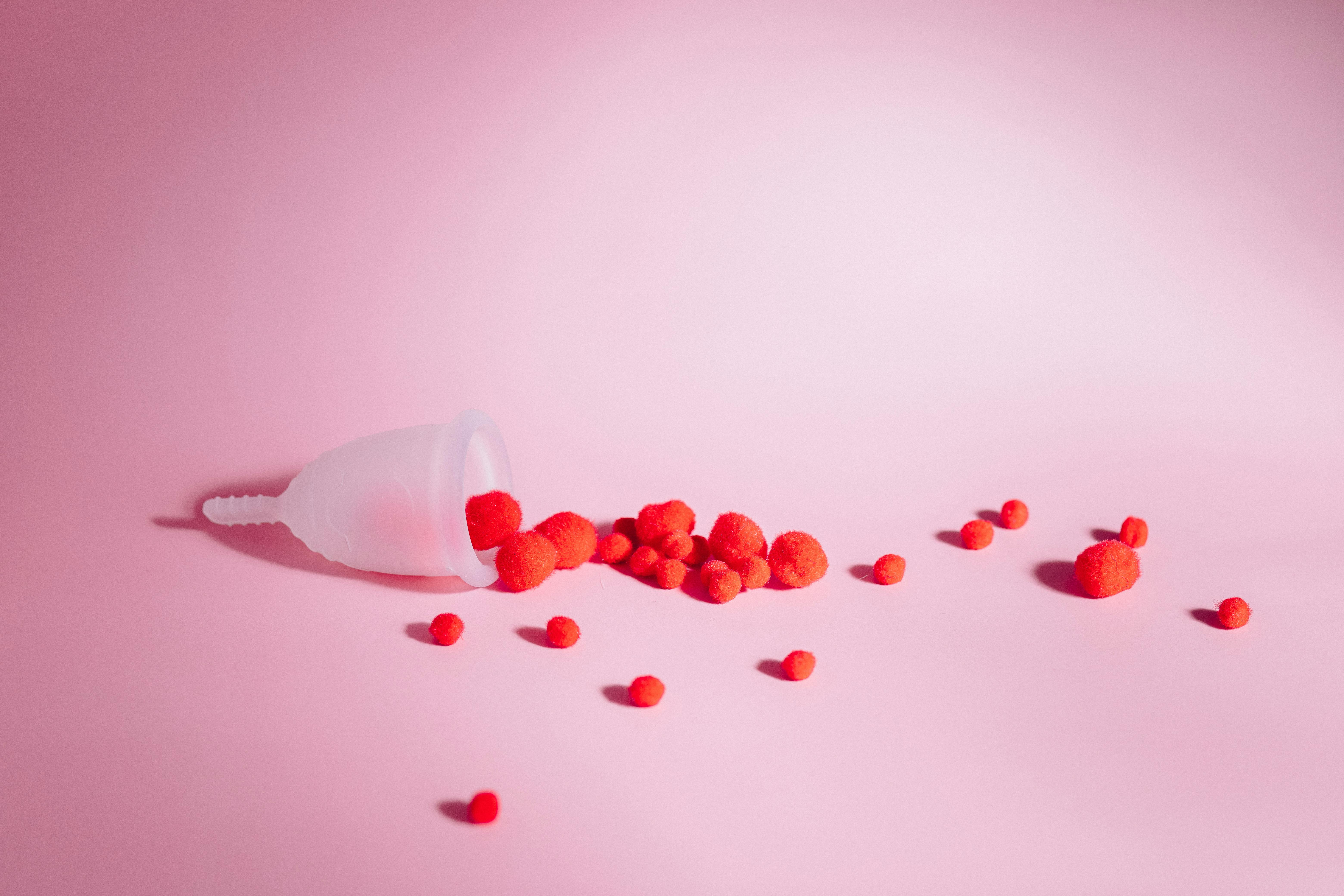 menstrual cup on bed with roses