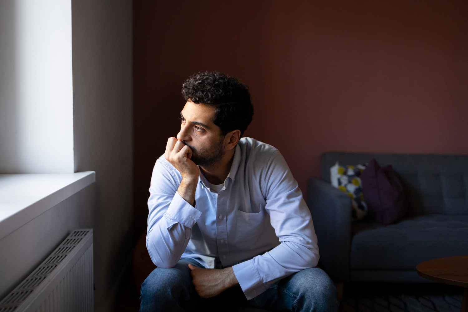 Anxious man in 40s looking out the window